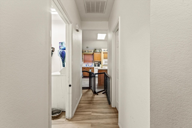 corridor with light hardwood / wood-style floors