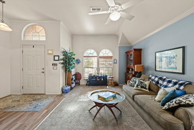 living room with lofted ceiling, hardwood / wood-style flooring, ornamental molding, and ceiling fan