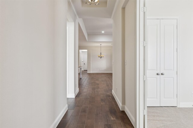 corridor featuring dark wood-type flooring and a chandelier