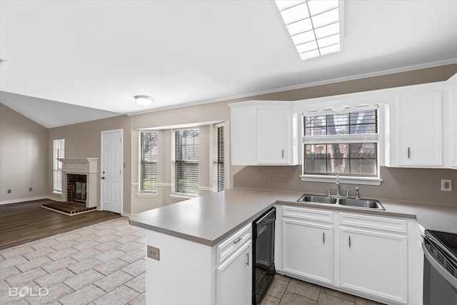 kitchen featuring dishwasher, sink, kitchen peninsula, a fireplace, and white cabinets