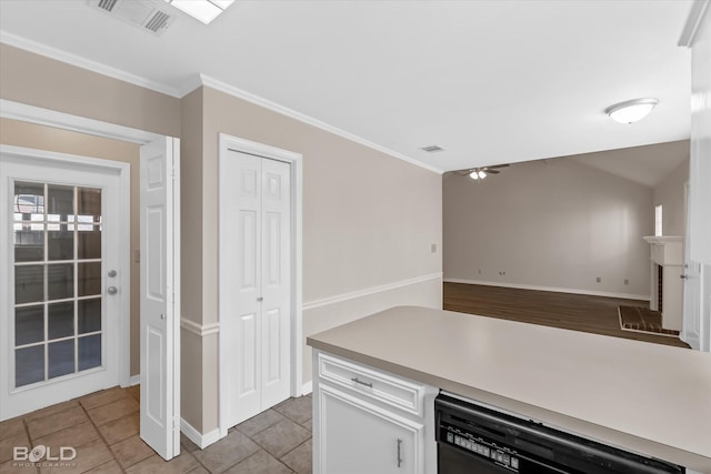 kitchen with crown molding, ceiling fan, light tile patterned floors, black dishwasher, and white cabinetry