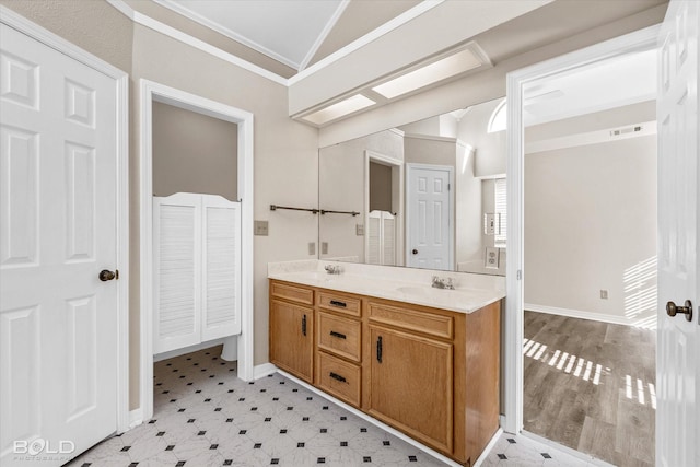 bathroom with vanity, vaulted ceiling, and ornamental molding