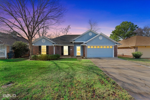 ranch-style house featuring a garage and a yard