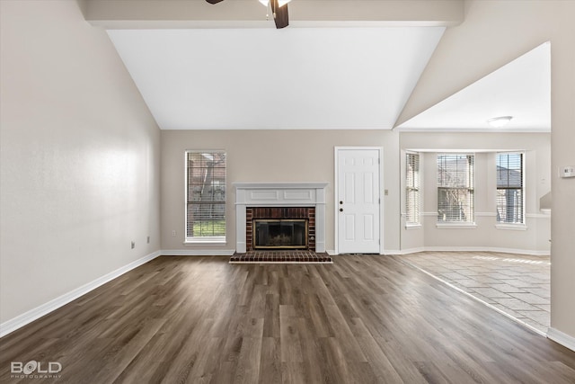 unfurnished living room featuring hardwood / wood-style floors, a brick fireplace, and a wealth of natural light