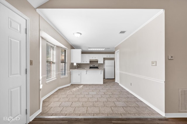 kitchen with sink, white cabinetry, white refrigerator, ornamental molding, and stainless steel electric stove