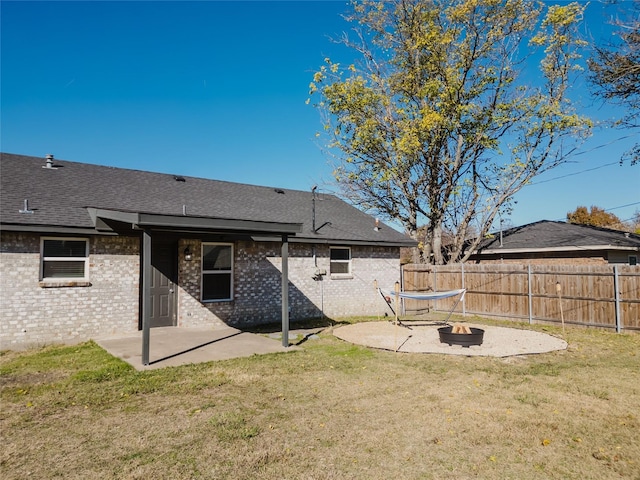 back of house featuring a patio area, a yard, and a fire pit