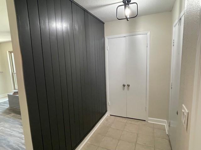 interior space featuring wood walls and a textured ceiling