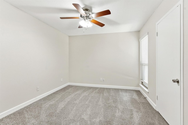 carpeted spare room featuring ceiling fan