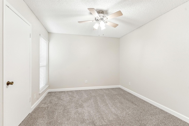 carpeted empty room with ceiling fan, a healthy amount of sunlight, and a textured ceiling