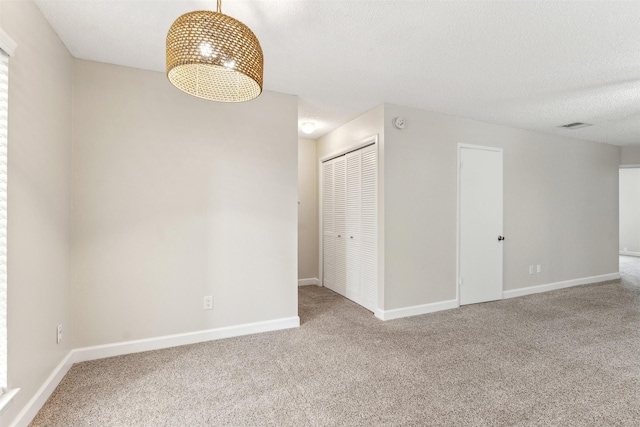 carpeted spare room with a textured ceiling