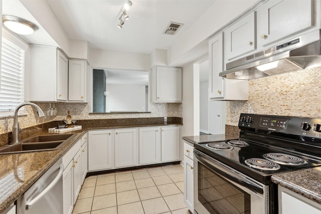 kitchen with appliances with stainless steel finishes, tasteful backsplash, sink, white cabinets, and light tile patterned floors