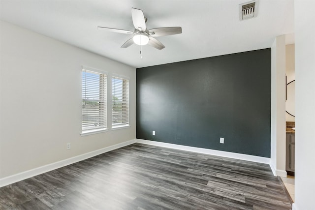 spare room featuring dark wood-type flooring and ceiling fan