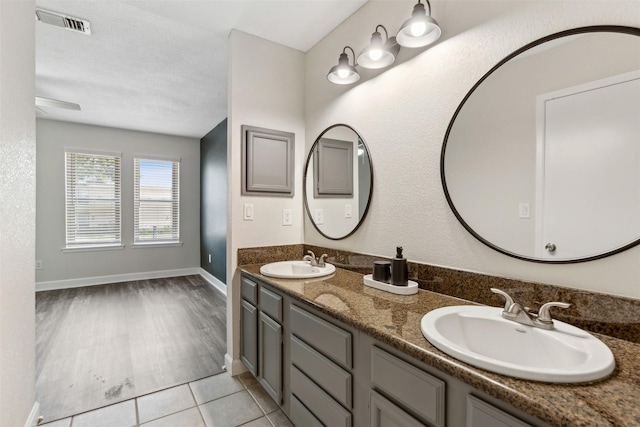 bathroom with tile patterned flooring, vanity, and a textured ceiling