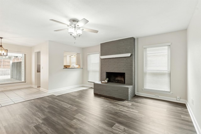 unfurnished living room with hardwood / wood-style flooring, plenty of natural light, ceiling fan, and a fireplace