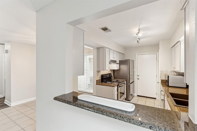 kitchen featuring white cabinetry, sink, tasteful backsplash, light tile patterned flooring, and appliances with stainless steel finishes