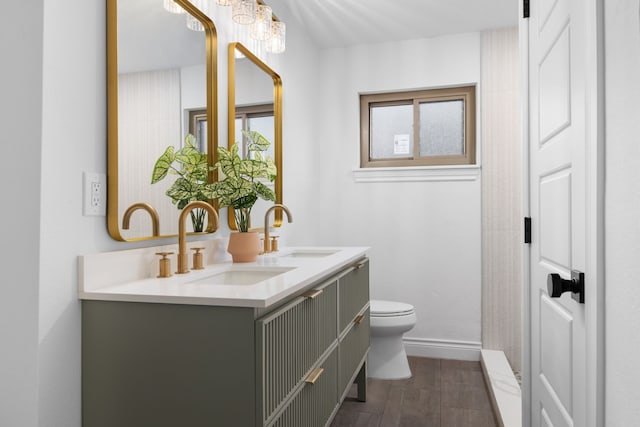 bathroom featuring toilet, vanity, a chandelier, and hardwood / wood-style flooring