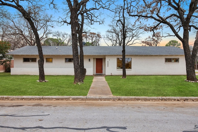 single story home featuring a lawn