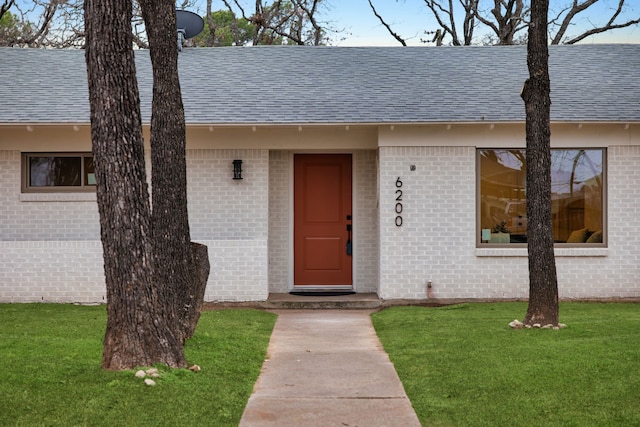 entrance to property with a lawn