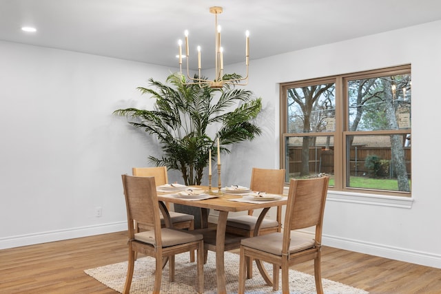 dining area with a notable chandelier and light hardwood / wood-style floors