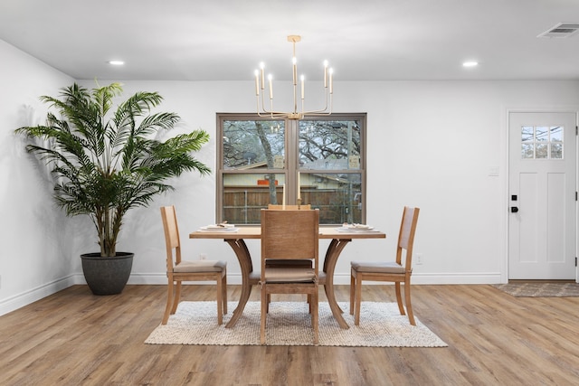 dining space with a chandelier and light wood-type flooring