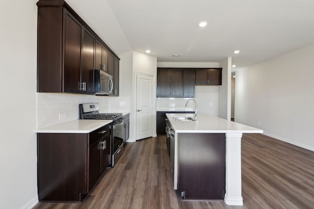 kitchen featuring stainless steel appliances, dark hardwood / wood-style flooring, a kitchen island with sink, and sink