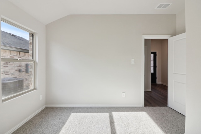 carpeted empty room with lofted ceiling