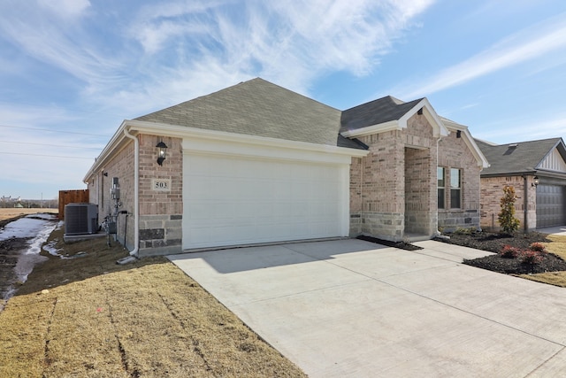 ranch-style home featuring a garage and cooling unit