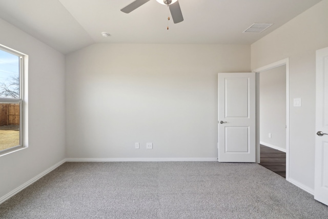 carpeted spare room featuring vaulted ceiling and ceiling fan