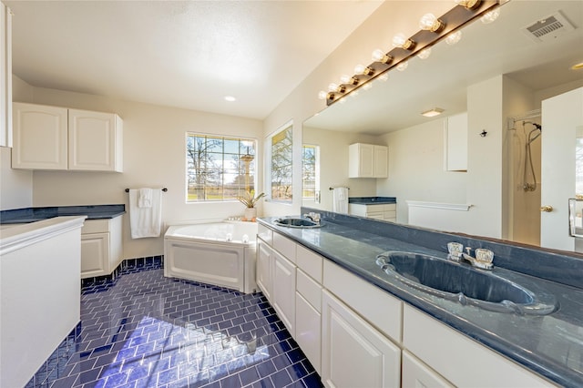 kitchen with white cabinetry, dark tile patterned flooring, and sink