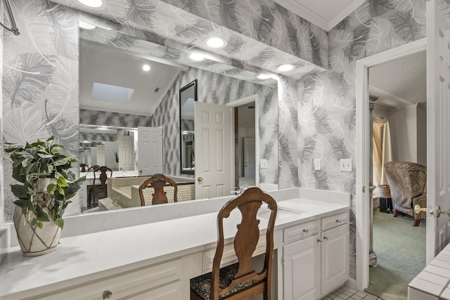 bathroom featuring ornamental molding, vanity, and a skylight