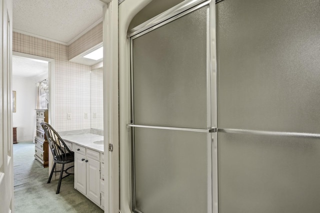 bathroom with crown molding, an enclosed shower, a textured ceiling, and vanity