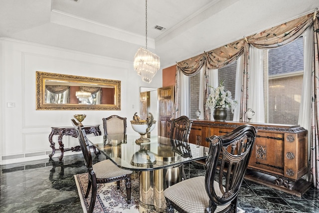 dining area featuring a raised ceiling, crown molding, and a chandelier