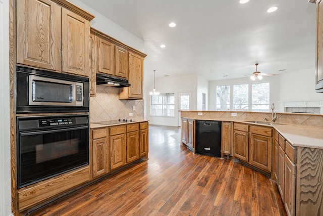 kitchen featuring decorative backsplash, dark hardwood / wood-style flooring, black appliances, ceiling fan with notable chandelier, and sink