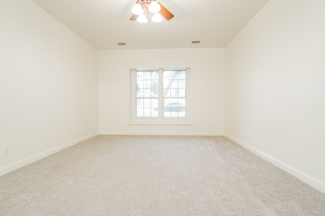 empty room featuring ceiling fan and light carpet