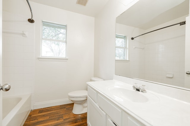 full bathroom with wood-type flooring, toilet, vanity, and tiled shower / bath