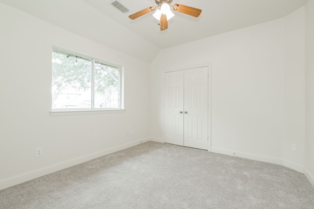 carpeted empty room featuring ceiling fan and vaulted ceiling