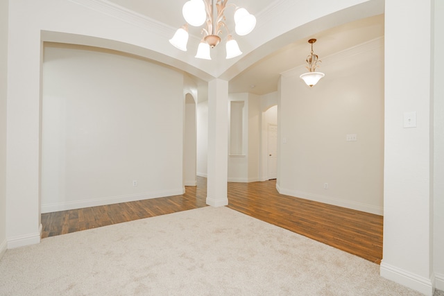 unfurnished room featuring an inviting chandelier, carpet flooring, and ornamental molding