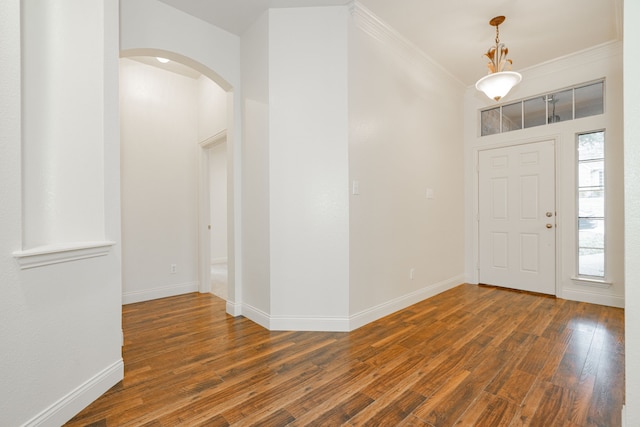 entrance foyer with dark wood-type flooring and crown molding