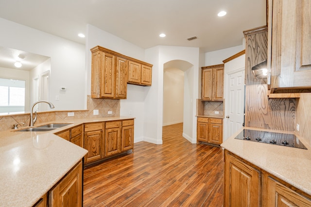 kitchen with dark wood-type flooring, sink, black electric stovetop, and tasteful backsplash