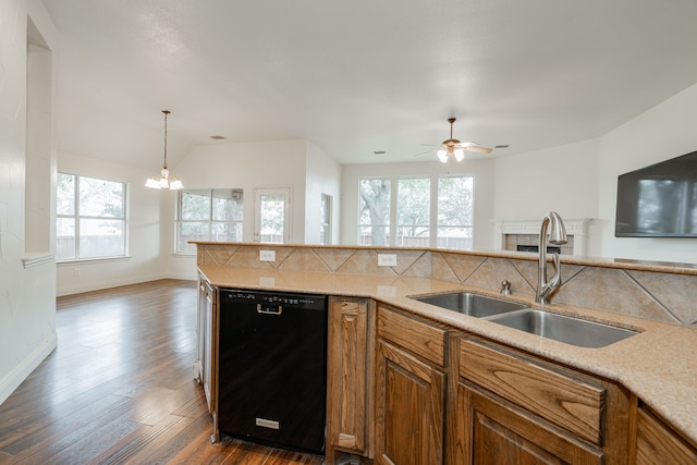 kitchen with ceiling fan with notable chandelier, pendant lighting, dishwasher, sink, and backsplash