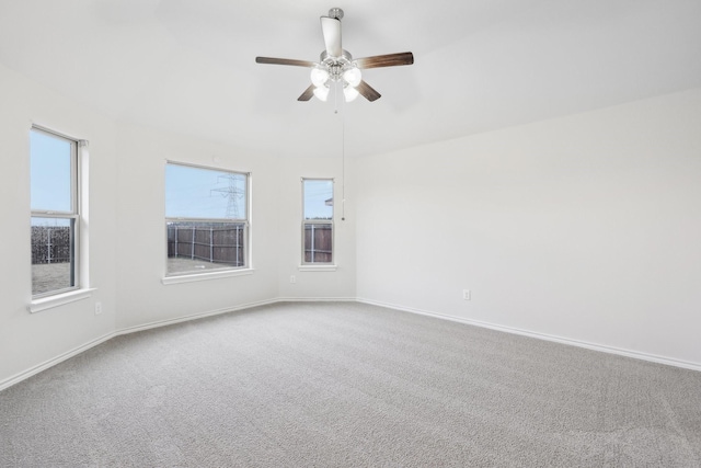 carpeted empty room with a wealth of natural light and ceiling fan