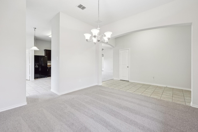 empty room with vaulted ceiling, light carpet, and a chandelier