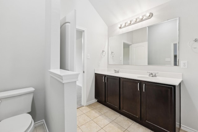 bathroom with tile patterned floors, vanity, vaulted ceiling, and toilet