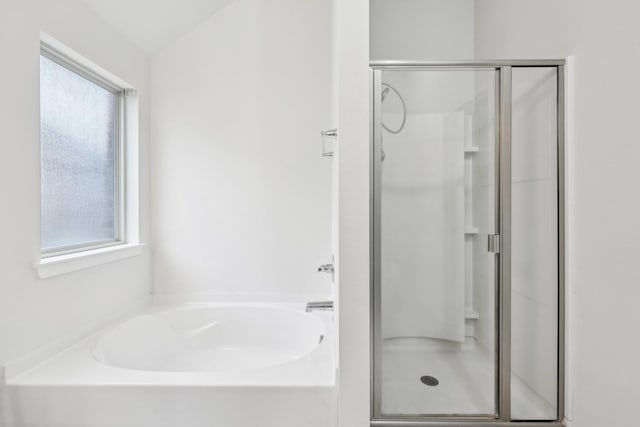 bathroom featuring vaulted ceiling and independent shower and bath