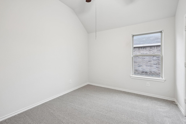 spare room featuring ceiling fan, carpet floors, and vaulted ceiling