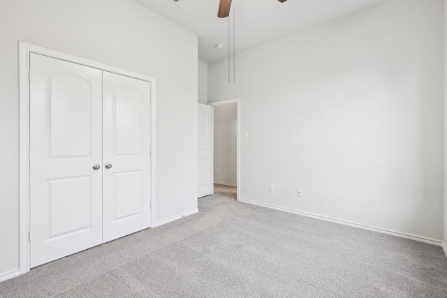 unfurnished bedroom with light carpet, a closet, and ceiling fan