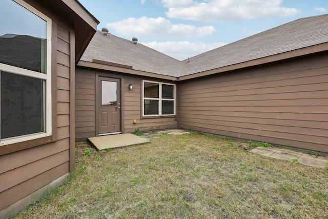 entrance to property with a lawn