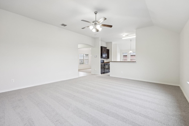 unfurnished living room featuring ceiling fan, light colored carpet, and vaulted ceiling