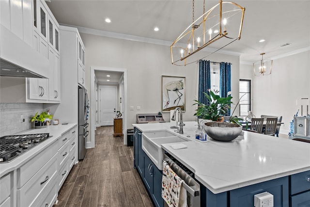 kitchen with white cabinets, decorative light fixtures, blue cabinetry, and appliances with stainless steel finishes