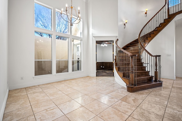 tiled entryway featuring a high ceiling and a notable chandelier